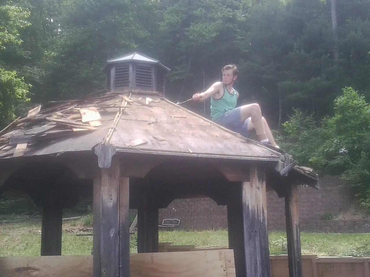Tearing the old roof off a wooden gazebo before new shakes in Northborough