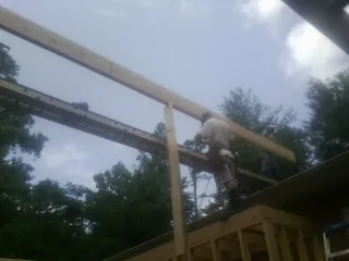 Carpenter setting a ridge beam over a new addition frame — Ice Dam Removal by Roofing Brothers in Northborough