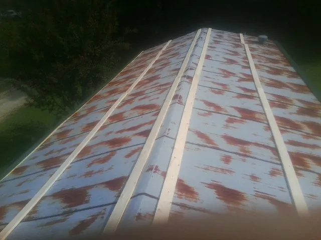Rusted metal roof panels with new wood purlins before replacement — Storm Damage Roof Repair in Northborough by Roofing Brothers