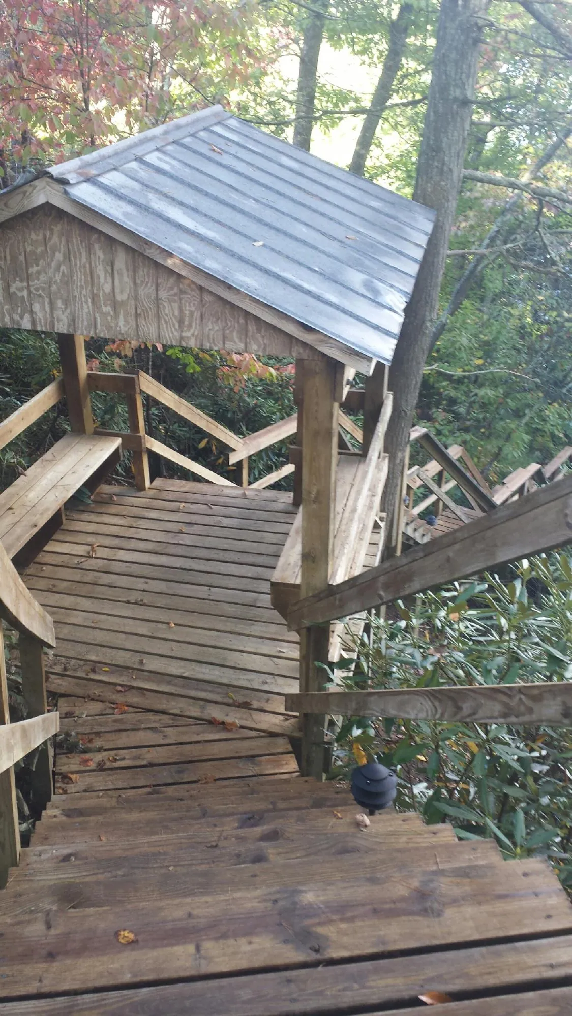 Metal roofed shelter over wooden steps on a wooded walkway — Skylight Repair & Installation work by our crew in Northborough
