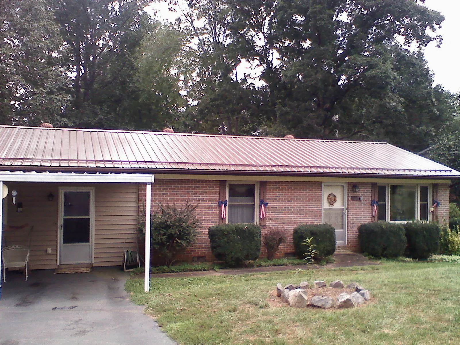 Bronze metal roof and carport on a brick ranch home — Roof Repair work by our crew in Northborough